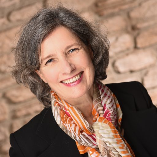 Angled headshot of a smiling Christina Winkler with a colorful scarf around her neck, illustrating that Christina Winkler is a highly skilled therapist supervisor with over 20 years of experience and a diverse set of academic credentials.