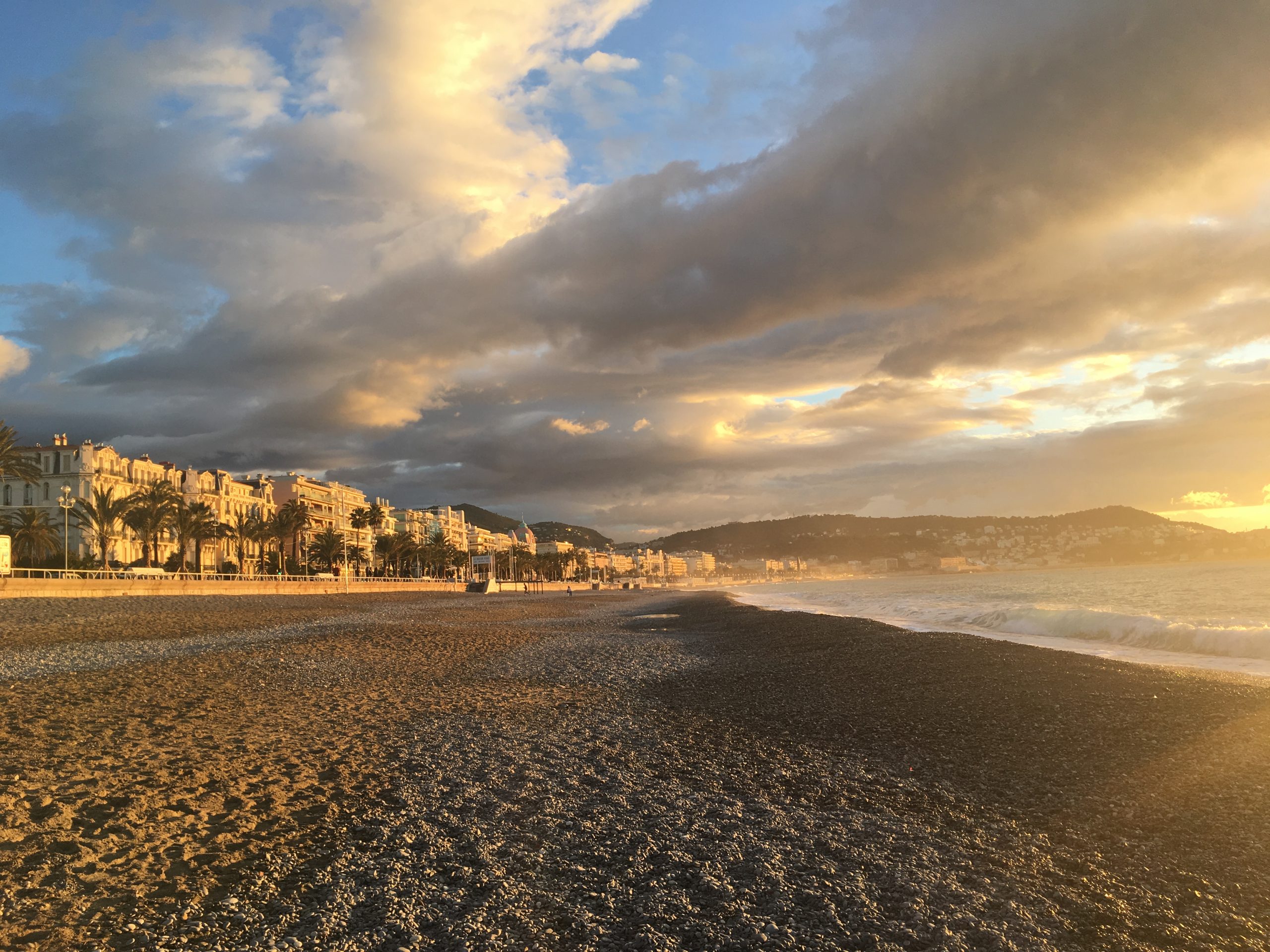 Cloudy skies over a European resort town on a beach, illustrating that Christiana Winkler provides supervision workshops in Nice, to inspire you and help you cultivate the pleasure of being with your clients again.